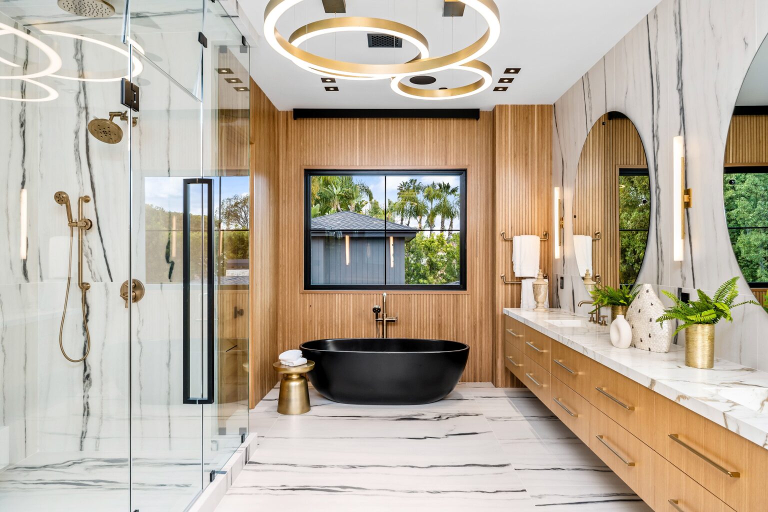 A modern luxury bathroom featuring a black bathtub and wooden accents